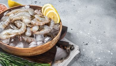 Uncooked Raw peeled tiger white shrimp prawn. Gray background. Top view. Copy space.